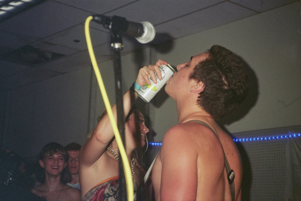 A girl pouring White Claw into the mouth of Bleach vocalist Jackson
